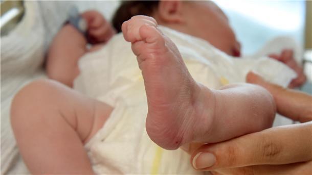Bild eines neugeborenen Säuglings und einer Frauenhand