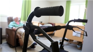 Rollator und ein Mann im Sessel