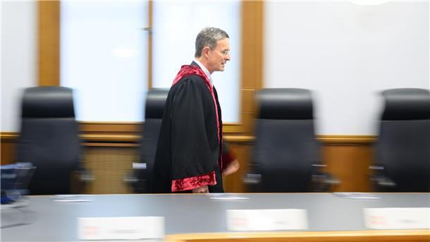 ein Richter in Robe betritt einen Gerichtssaal