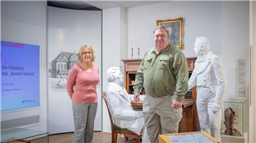 William C. Van Ronzelen III und seine Ehefrau Debra aus den USA sind in Bremerhaven auf den Spuren des Vorfahrens Jacobus van Ronzelen, der für den Bau des Hafens verantwortlich war. Im Historischen Museum stehen sie vor einer Gips-Statue van Ronzelens (stehend).
