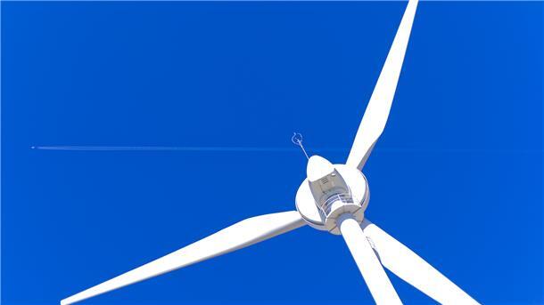 Windkraftanlage vor blauem Himmel.