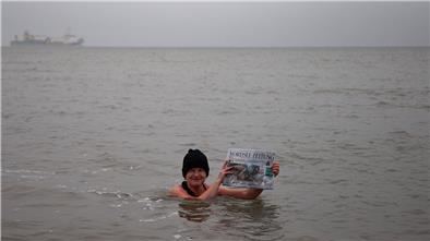 Winterbaden in der Grimmershörnbucht bei 3 Grad Luft- und 8 Grad Wassertemperatur: Zu Beweiszwecken hat NORD|ERLESEN-Redakteurin Heike Leuschner die Samstagausgabe der NORDSEE-ZEITUNG mit ins Wasser genommen.