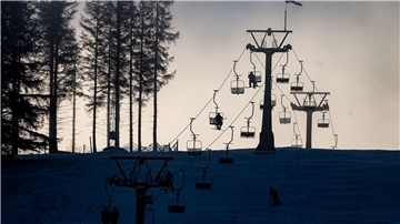 Wintersportler sitzen am Matthias-Schmidt-Berg im Harz in der Seilbahn.