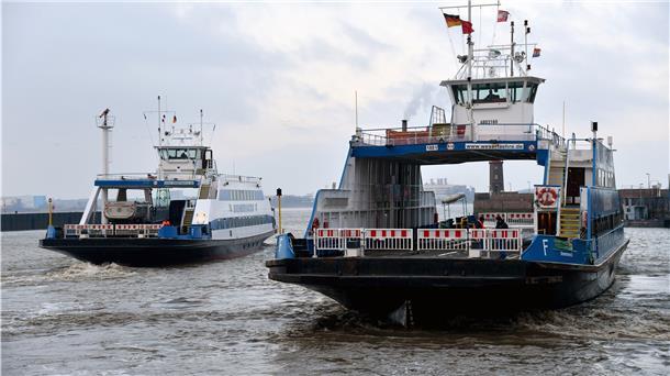 Zwei Fähren fahren nebeneinander über einen Fluss.
