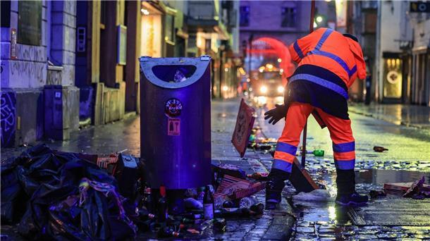 Wo gefeiert wird, fällt Müll an: Mitarbeiter der Straßenreinigung fegen in der Nacht in Köln den Abfall zusammen.