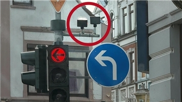 Blick auf eine Ampel und zwei Kameras, die eingekreist sind: Wofür sind die Kameras an Ampeln da? Und was können diese Geräte wirklich?