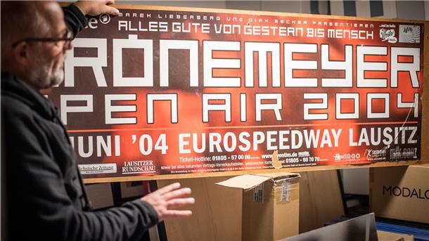 Wolfgang Heß mit einem Konzert-Poster in einem seiner Räume in Cadenberge, die unzählige Exponate beherbergen.