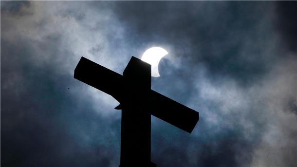 Millionen Menschen sehen totale Sonnenfinsternis Wolken lösen sich auf und geben über dem Kreuz eines Kirchturms in Manor (Texas) den Blick auf die beginnende Sonnenfinsternis frei.