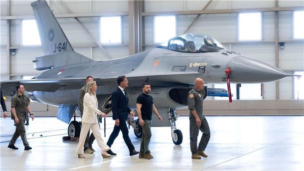 Wolodymyr Selenskyj (2.v.r) und Mark Rutte (M) laufen an einem F-16 Kampfjet vorbei.