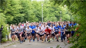 Eine große Gruppe Menschen in Sportsachen startet bei einem Lauf.