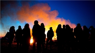 Zahlreiche Menschen stehen an einem Osterfeuer. Auch in der Region Zeven finden an den Feiertagen vielerorts Osterfeuer statt. Das erste Feuer wird bereits an Karfreitag entzündet.