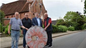 Zeigen eine alte Turmuhr vor dem sanierten Kirchturm: Werner Borchers vom Kirchenvorstand (von links), Bürgermeister Ulrich Mehrkens, Pastor Burghard Kurz und Klaus-Hermann Tomhave von der Baukommission der Kirchengemeinde.