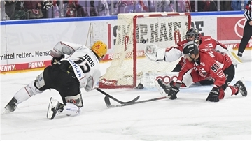 Eis Eishockey-Spieler schießt auf einem Bein knieend auf das Tor. Ziga Jeglic von den Fischtown Pinguins aus Bremerhaven.