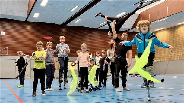 Kinder jonglieren, laufen auf Stelzen und machen Akrobatik.