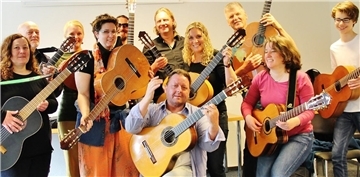 Teilnehmer eines Workshops mit Dozent Tim Schikoré (Mitte) während der Zevener Gitarrenwoche.