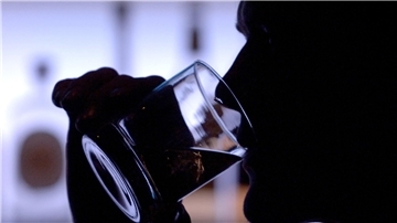 Ein Mann trinkt ein Glas Whiskey an einer Bar