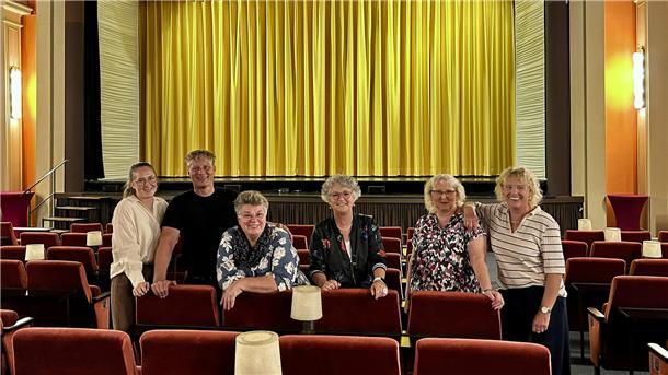 Eine Gruppe von Menschen steht zwischen den Kinosesseln im Central Theater Brake.