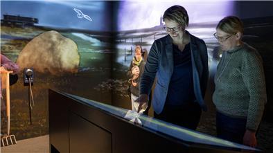 Klimahaus eröffnet neu gestalteten Hallig-Ausstellungsraum Zwei Frauen stehen in einem Ausstellungsraum und schauen auf eine interaktive Ausstellungstafel