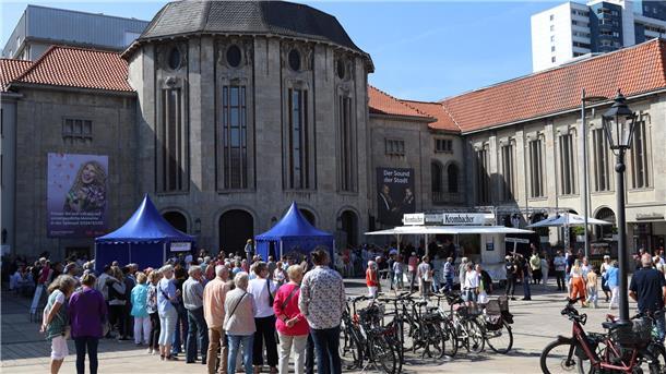 Menschen stehen vor dem Gebäude des Bremerhavener Stadttheaters. 