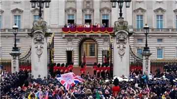 ZUschauer jubeln nach der Krönung von König Charles III. und Königin Camilla vor dem Buckingham Palast in London.