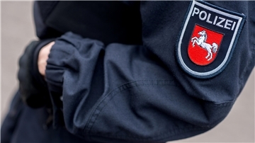 Eine Polizeibeamtin steht im Innenhof einer Polizeiinspektion 