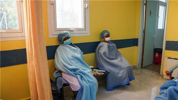 18 Tote bei schweren Bootsunglücken in der Ägäis Zwei Frauen sitzen nach ihrer Rettung in Decken gewickelt zur Behandlung in einem Krankenhaus auf Lesbos.