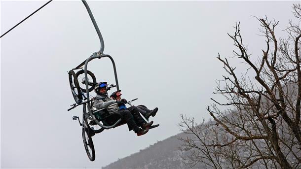 Viele Wintersportler im Harz unterwegs Zwei Männer sitzen mit ihren Mountainbikes in einem Sessellift.
