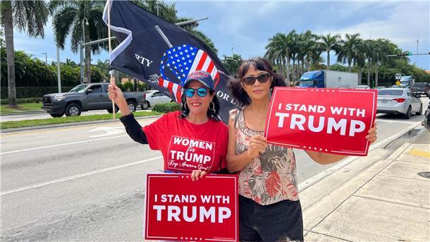 Historischer Auftritt Trumps vor Gericht in Miami Zwei Trump-Anhängerinnen empfangen den Ex-Präsidenten vor seinem Hotel in Miami mit Schildern, auf denen „Ich stehe hinter Trump“ geschrieben steht.