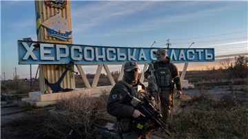 Zwei ukrainische Soldaten stehen neben einem Schild mit der Aufschrift „Region Cherson“. Die Stadt Cherson wurde Mitte November von der Ukraine zurückerobert.